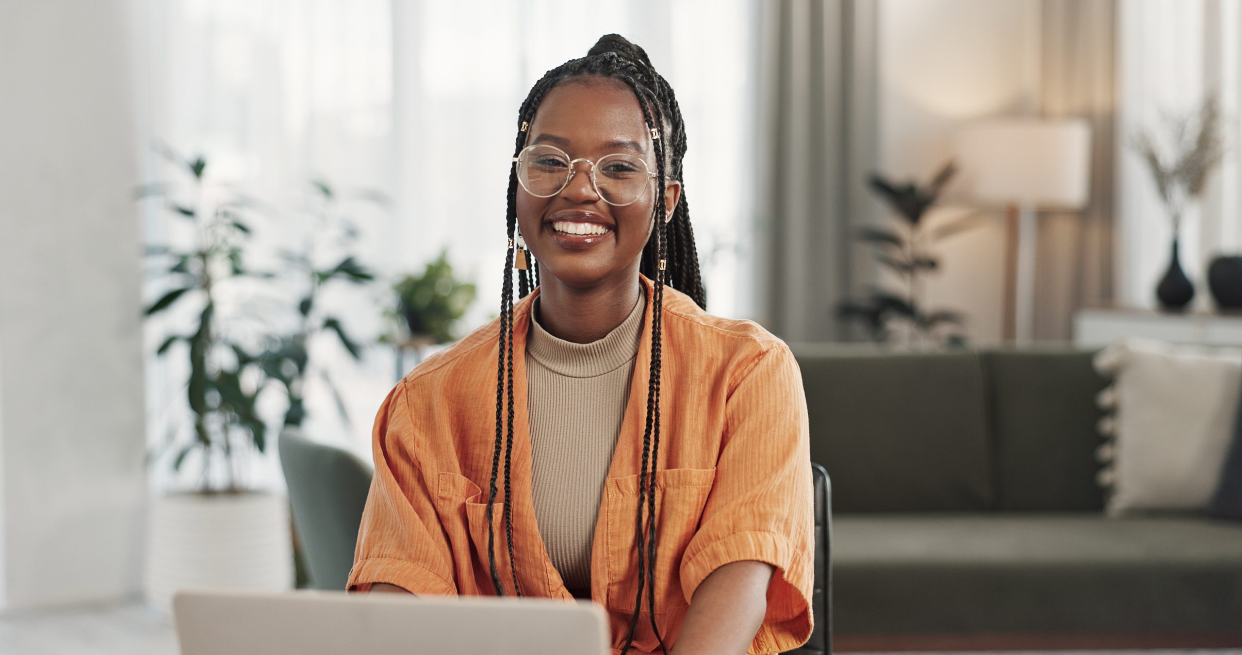 Black woman, portrait in home office and laptop for remote work, social media or blog research with smile in apartment. Happy freelancer at desk with computer for email, website or online in house.